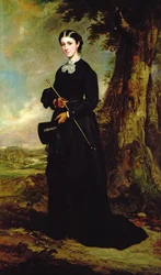 Jonge vrouw in een zwart rijgewaad staand in een landschap